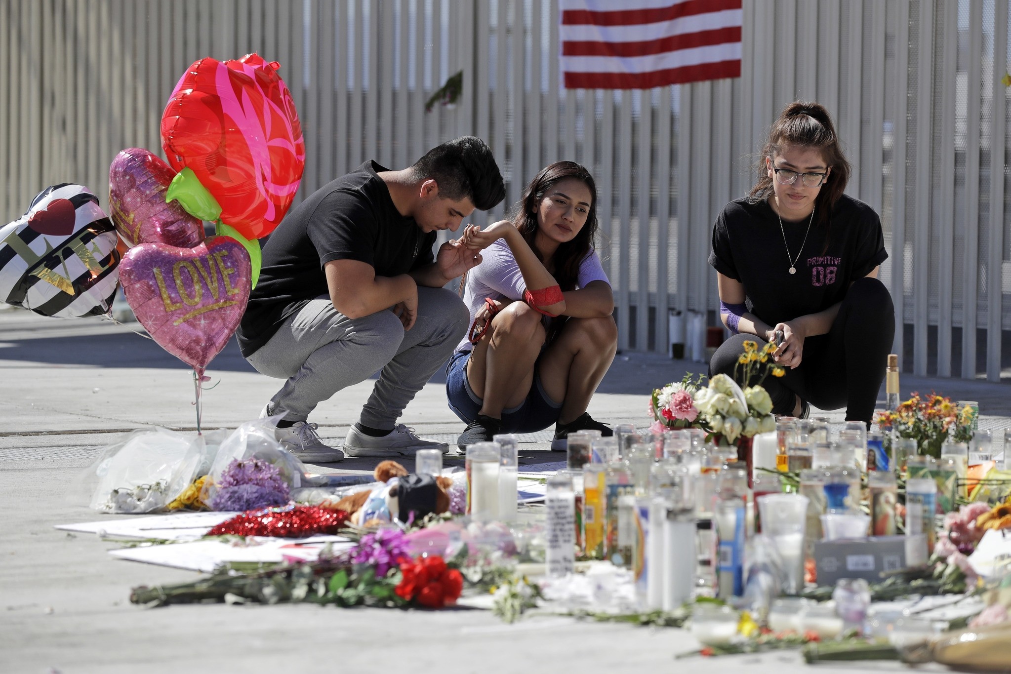 Roberto Lopez, from left, Briana Calderon and Cynthia Olvera, of Las Vegas, pause at a memorial site on Tuesday, Oct. 3, 2017 in Las Vegas. (AP Photo)