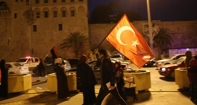 مواطن ليبي يرفع العلم التركي في شوارع طرابلس احتفالاً بقرار أنقرة إرسال قوات إلى ليبيا