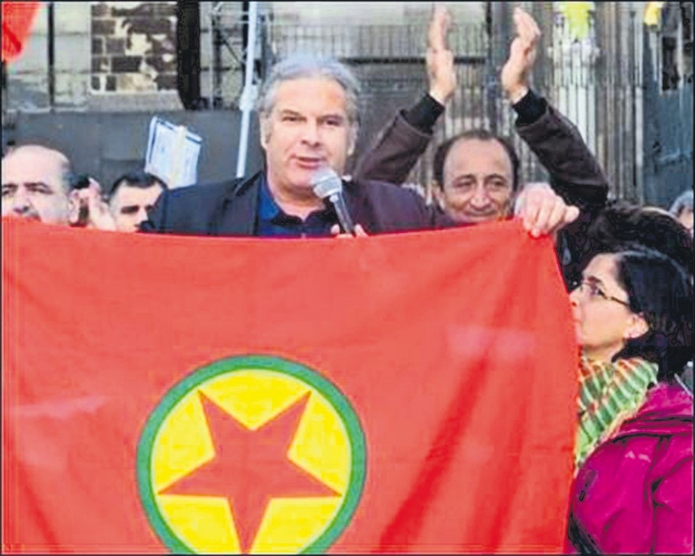 Anrej Hunko poses with a PKK banner, the terror group outlawed by the EU.