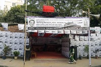 A Bangladeshi woman passes by a temporary election camp installed ahead of 11th national elections for parliament in Dhaka, Bangladesh, Dec. 12.