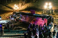 Bystanders and rescue personnel gather near the wreckage of a bus on a road near Skopje on February 13, 2019. (AFP Photo)