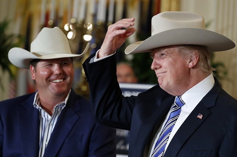 In this July 17, 2017, photo, President Donald Trump tries on a Stetson hat, as Dustin Noblitt, with Stetson Hats, smiles, during a ,Made in America,, product showcase at the White House in Washington. (AP Photo)