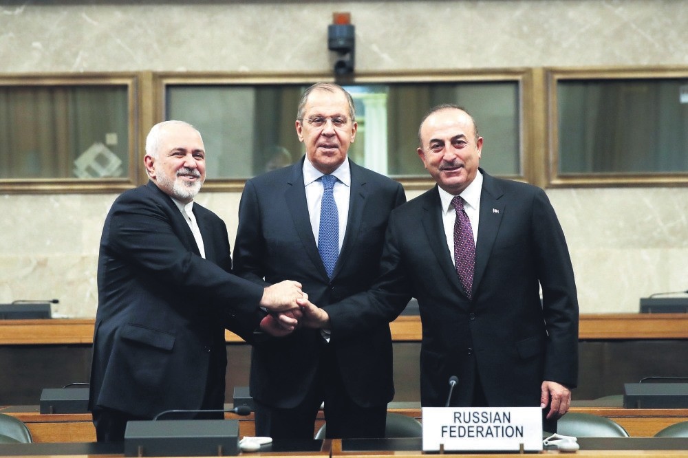 Iranian FM Mohammad Javad Zarif (L), Russian FM Sergei Lavrov (C), and FM Mevlu00fct u00c7avuu015fou011flu (R) shake hands after a joint statement following consultations on Syria, at the European headquarters of the U.N. in Geneva, Switzerland, Dec. 18.