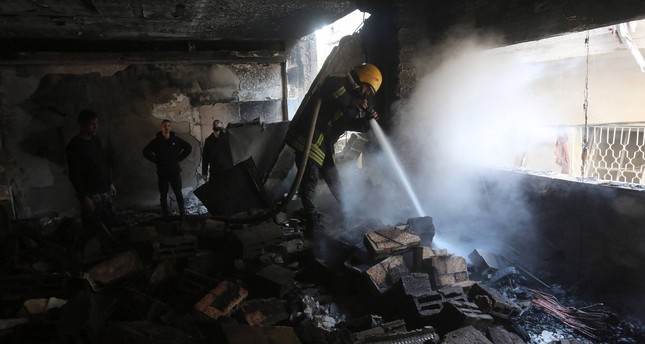رجل إطفاء يعمل على إخماد حريق في منزل سكني بمخيم نور شمس للاجئين شمال غربي الضفة الغربية بعد عمليات تفجير واقتحام لجيش الاحتلال الإسرائيلي، 26-12-2023 صورة: الأناضول