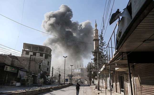 A picture taken on February 21, 2018 shows a smoke plume rising following a reported regime air strike in the opposition-held enclave of Hamouria in the Eastern Ghouta near Damascus. (AFP Photo)