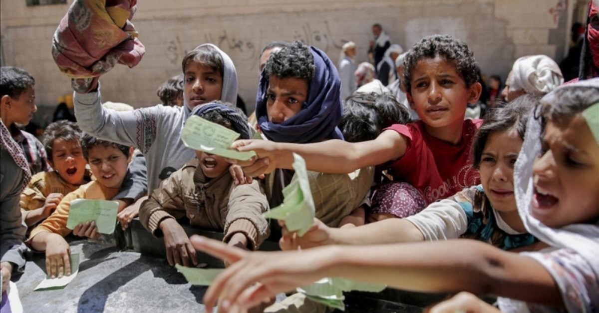 Yemeni children present documents to receive food (AP File Photo)