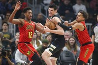 Bucks forward Ersan Ilyasova (7) controls the ball between Hawks forward De'Andre Hunter (12) and guard Trae Young (11) in the first half at State Farm Arena, Atlanta, Georgia, Dec 27, 2019. (Brett Davis-USA TODAY Sports via Reuters)