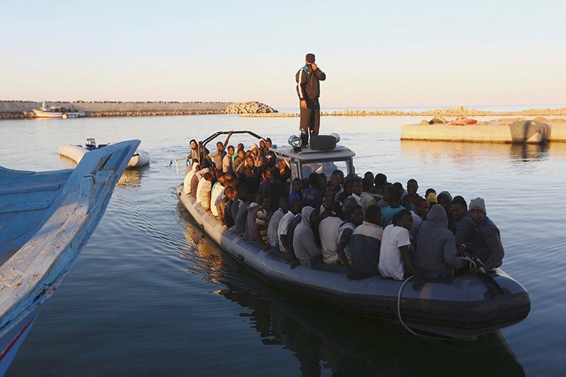 frican migrants are seen seated in a boat, after being rescued by the Libyan navy following their boat suffering engine failure, near the coastal town of Gharaboli (Reuters Photo)