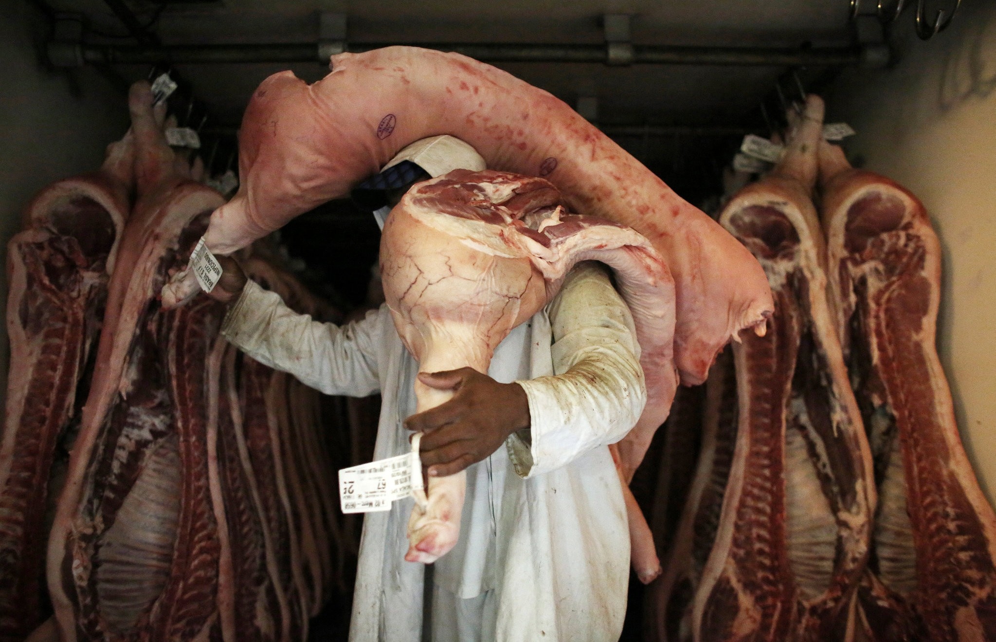 An employee carries pieces of meat at a butchery in Sao Paulo, Brazil October 10, 2014. Picture taken October 10, 2014. (REUTERS Photo)