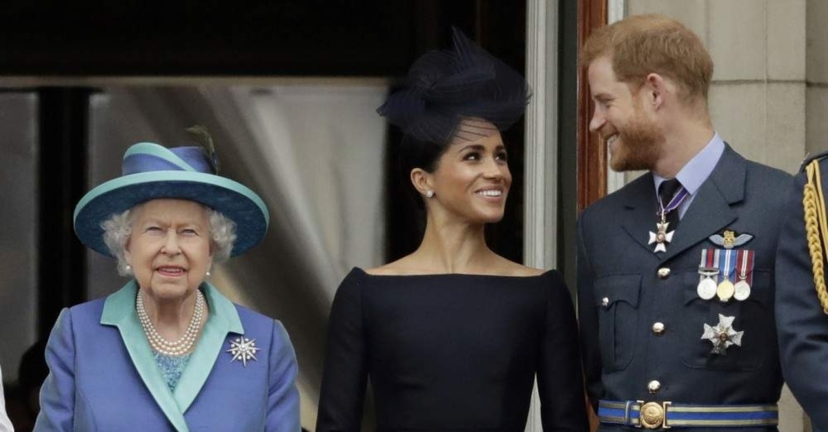 Britain's Queen Elizabeth II, Meghan the Duchess of Sussex and Prince Harry watch a flypast of Royal Air Force aircraft over Buckingham Palace, London, July 10, 2018. (AP Photo)