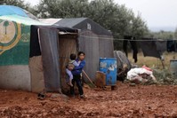 Syrian children, who fled air strikes in their hometown, are pictured near tents at an informal camp for displaced people where they live with their families in Idlib, Jan. 7, 2020.  (AFP PHOTO)