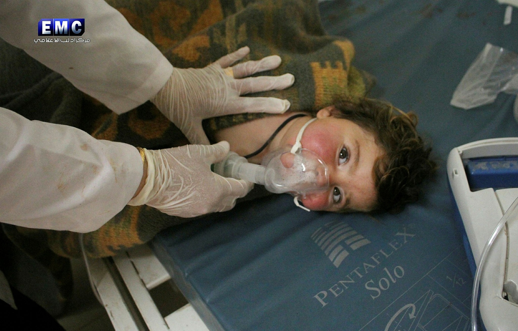 This photo provided by Edlib Media Center shows a Syrian doctor treating a child following a suspected chemical attack.