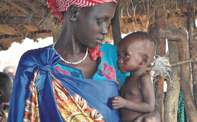 A woman holds her severely malnourished 10-month old daughter at the feeding center for children, South Sudan, Dec. 10, 2017.