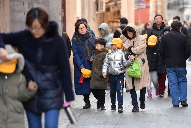 Parents and family members escort their children just outside the gates of an elementary school in Beijing following an attack on January 8, 2019 (AFP Photo)