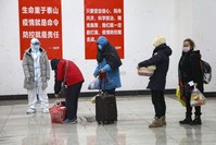 A medical worker in a protective suit looks at patients who diagnosed with the coronaviruses arrive at a temporary hospital which transformed from an exhibition center in Wuhan in central China's Hubei province, Feb. 5, 2020. (AP Photo)