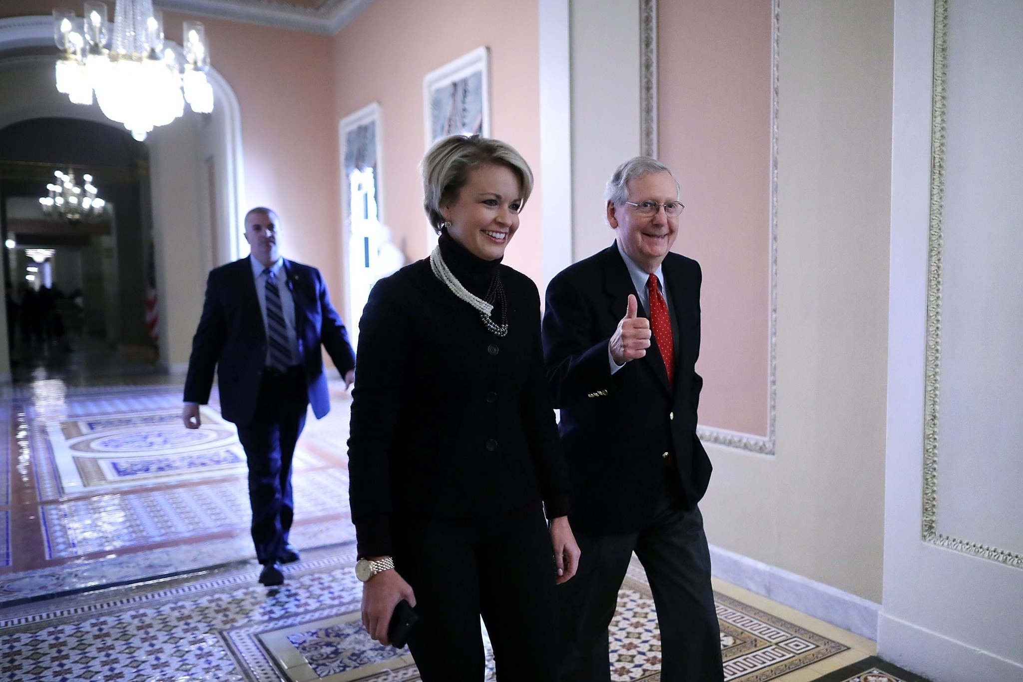 Senate Majority Leader Mitch McConnell (R-KY) gives a thumbs-up as he and his Director of Operations Stephanie Muchow head for the Senate floor at the U.S. Capitol December 1, 2017 in Washington, DC. (AFP Photo)