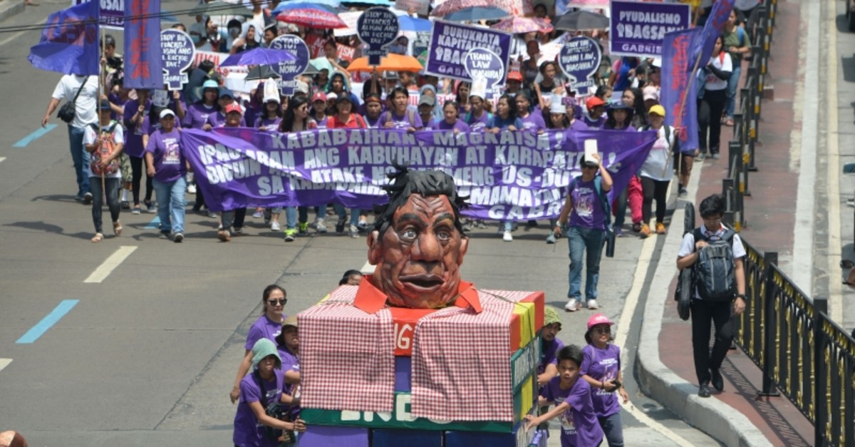 Activists from Gabriela push a carriage with an effigy of Philippines' President Rodrigo Duterte as they march toward Malacanang palace to commemorate International Women's Day in Manila on March 8, 2019. (AFP Photo)
