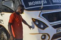 A man points at a bullet-hole on a bus which was ambushed by al-Shabab gunmen in the Nyongoro area of Lamu county, near the Indian Ocean coast of Kenya Thursday, Jan. 2, 2020. Kenyan police say four people have been killed in two ambushes. (AP Photo)