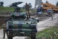 Turkish soldiers on an armored personnel carrier secure a staging area for troops preparing tanks to enter combat and join a military offensive against the YPG in northern Syria, Jan. 23. 