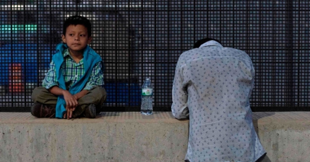 Josu00e9 (R), 27, and his son, Josu00e9 Daniel, 6, wait after crossing the border into the US, May 16, 2019, in El Paso, Texas. Both spent a month trekking across Mexico from Guatemala. (AFP Photo)