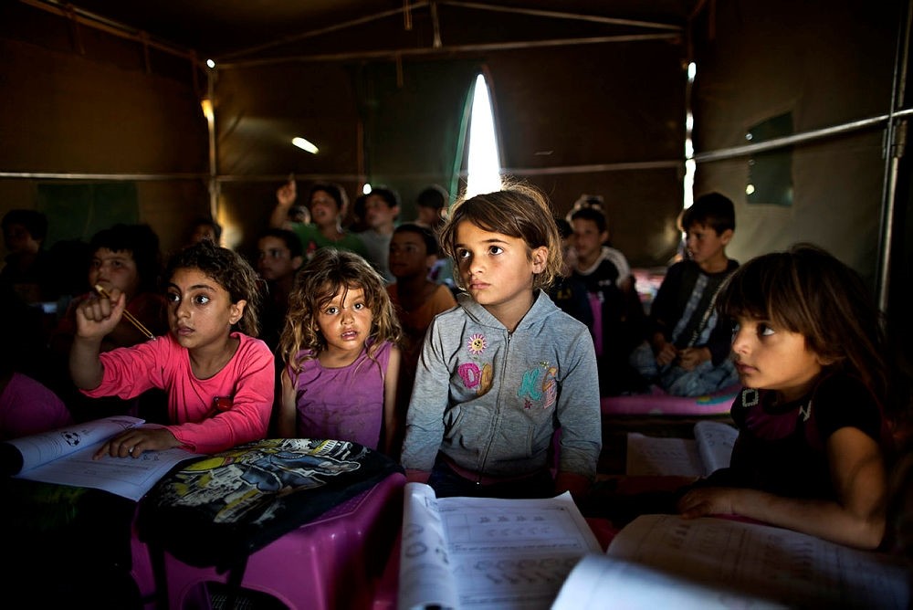 Syrian refugee children attend a class at a makeshift school set up in a tent at an informal tented settlement near the Syrian border on the outskirts of Mafraq, Jordan.(AP Photo)