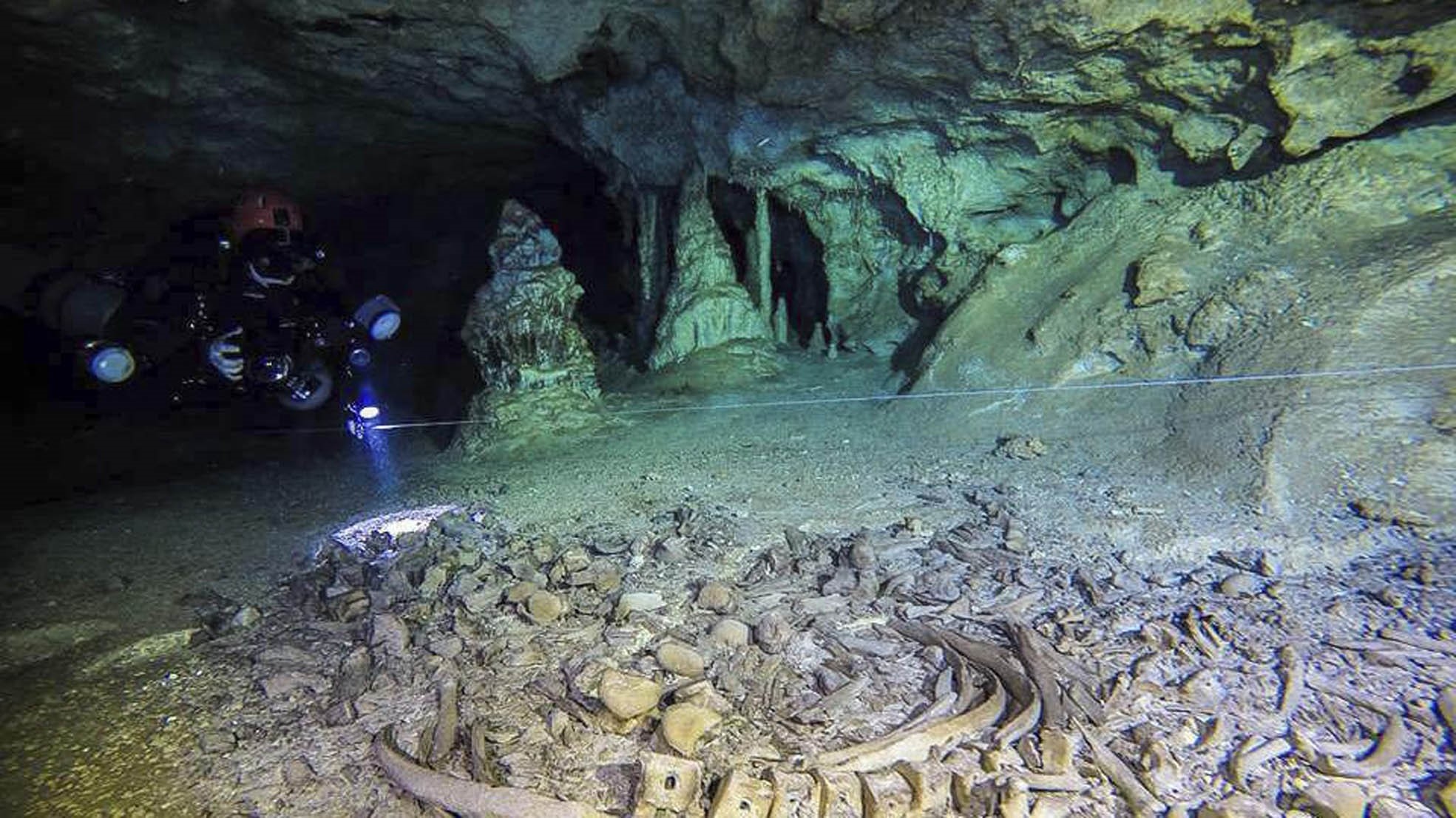 Divers explores the underwater cave system where human and animal remains have been found submerged in Mexico.