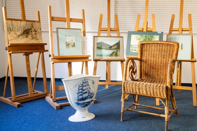 A picture taken on February 8, 2019 at the Weidler auction house in the southern German city of Nuremberg shows a wicker armchair, bearing a swastika, a vase and watercolours which are presumed to have belonged to Hitler (AFP Photo)