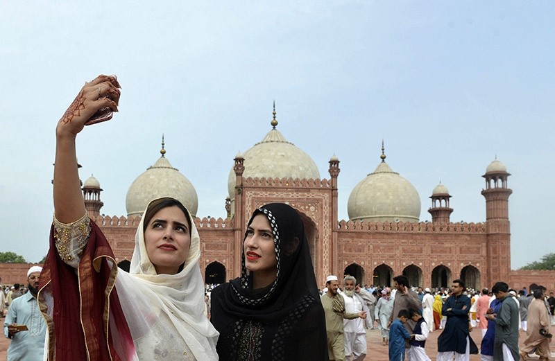 Pakistani women take selfie photographs after offering Eid al-Fitr prayers at the Badshahi Masjid in Lahore on July 6, 2016. (AFP Photo)