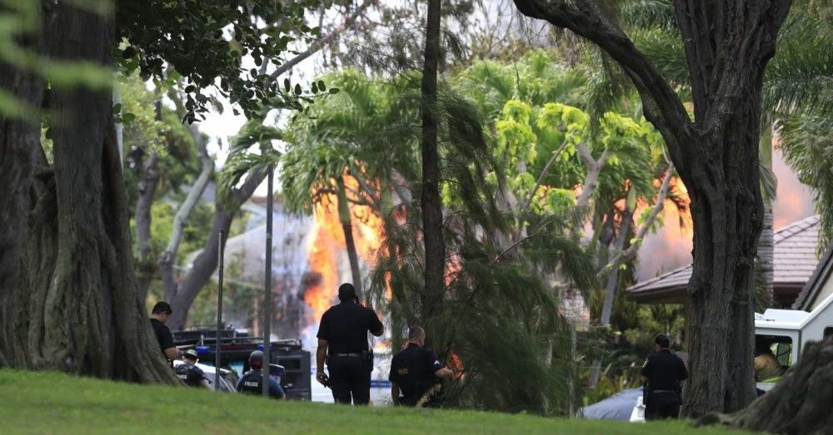 Honolulu police watch a house fire after a shooting and domestic incident at the residence on Hibiscus Road near Diamond Head, Honolulu, Jan. 19, 2020. (AP Photo)