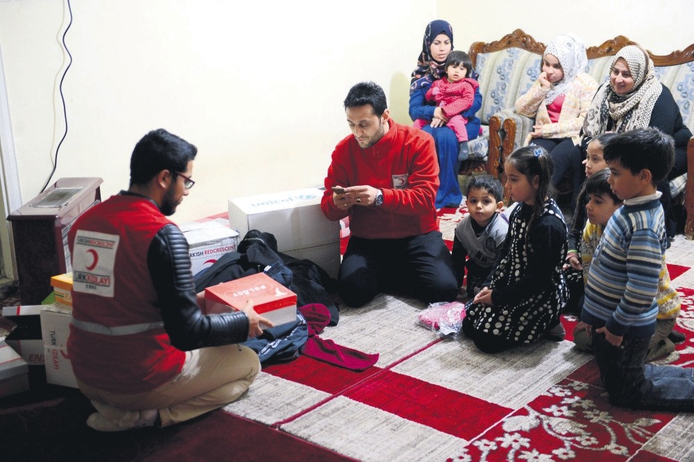 Turkish Red Crescent staff deliver clothes and shoes to al-Ahmad family in the city of Kilis. The family of nine, including quintuplets, relies on aid as the parents are unemployed.