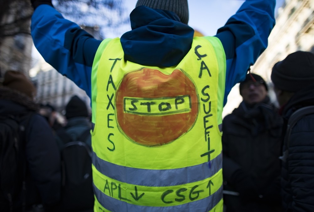 A yellow vest bears the message u2018Stop Taxesu2019 as high school students and union workers take part in a demonstration for pensions and social conditions, Paris, France, Friday.