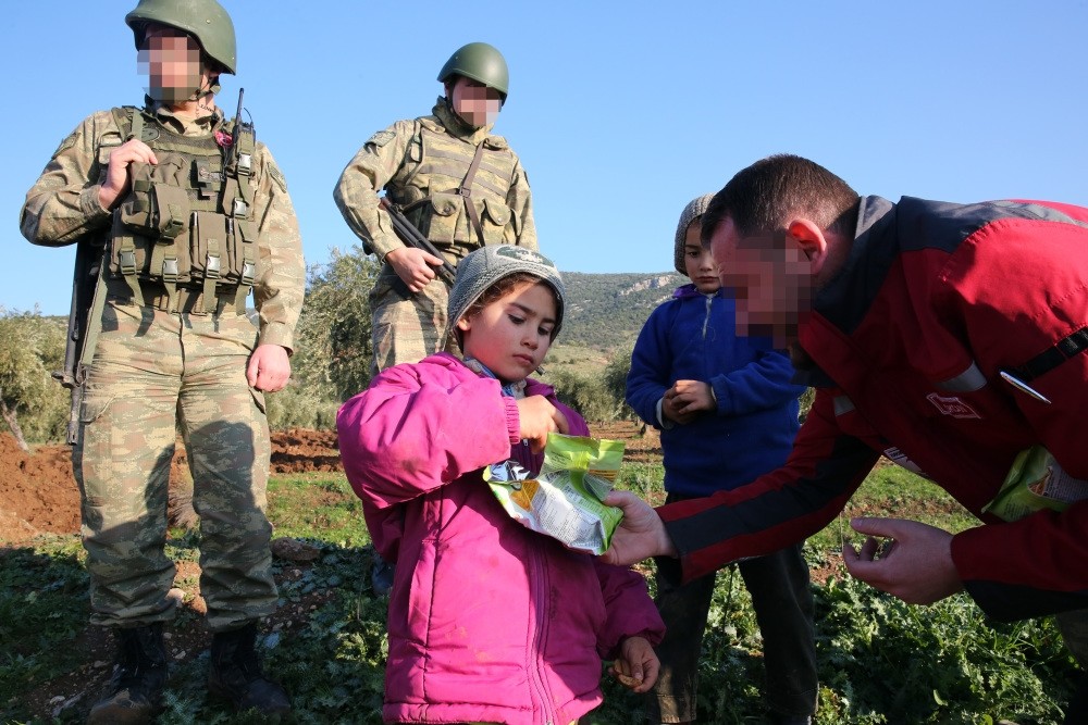 A Syrian child, who lives in village of the Sorke in northern Afrin, receives food aid from a Turkish soldier, Syria, Feb. 2.