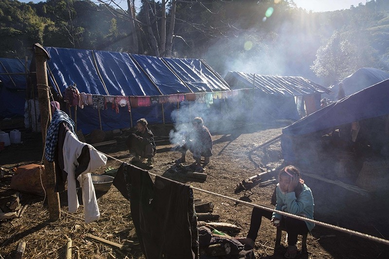 Refugees in front of their temporary shelter near Lung Byeng village, Waimaw township in Kachin state, Myanmar. Jan. 2017. (AFP File Photo)