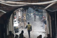 Police officers cordon off the site of a fire in a narrow lane in New Delhi, India, Sunday, Dec. 8, 2019. (AP Photo)