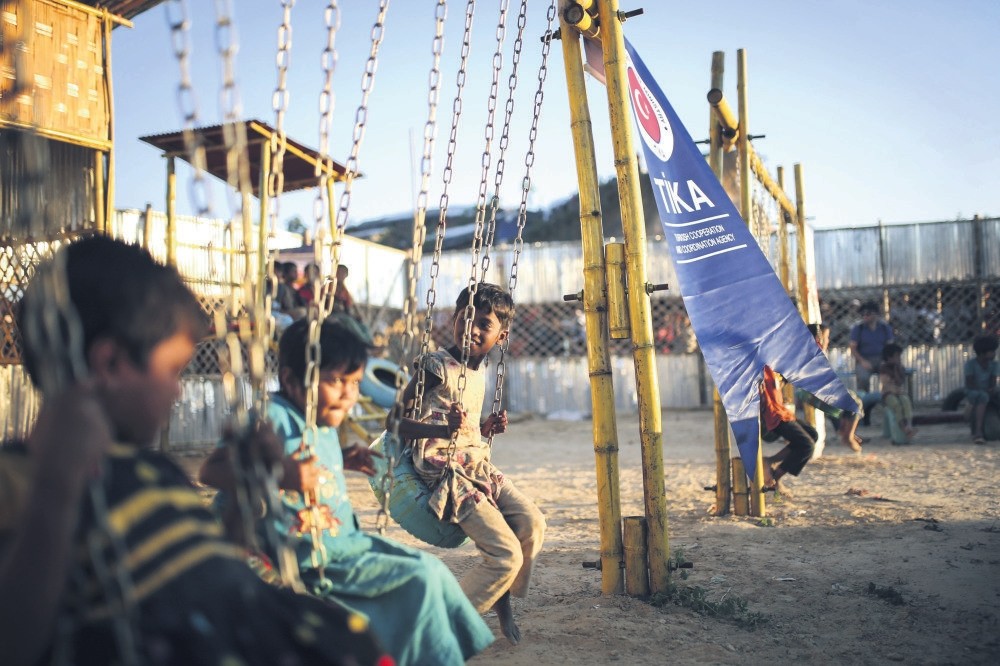 Rohingya refugee children sit on swings in a playground established by the Turkish Cooperation and Coordination Agency (Tu0130KA), Bangladesh, June 6. 