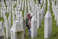 A Bosnian Muslim woman walks among gravestones at the memorial center of Potocari, Srebrenica, July 11, 2018.