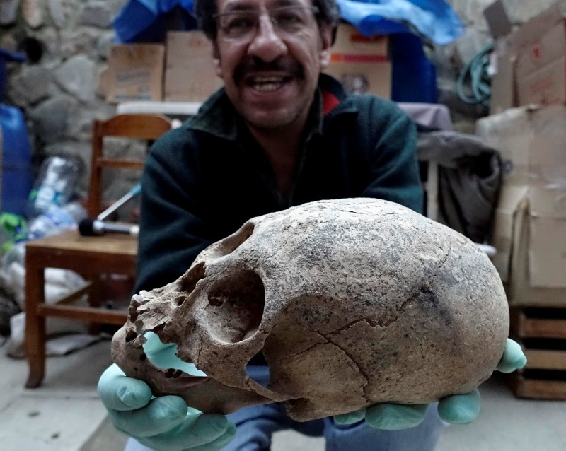 Archeologist Jedu Sagarnaga holds a skull as part of an archeological finding, dated approximately 500 years ago, in Mazo Cruz, near Viacha, Bolivia, November 12, 2018. (Reuters Photo)
