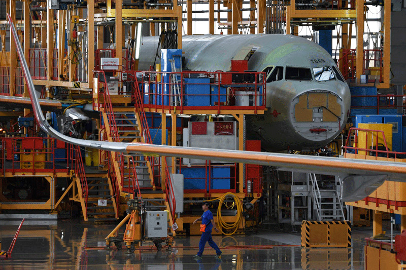 This file picture shows a worker walking past planes under construction at the Airbus A320 Family Final Assembly Line (AFP File Photo)