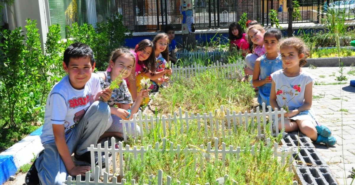 Children pose with the herbs they grew.