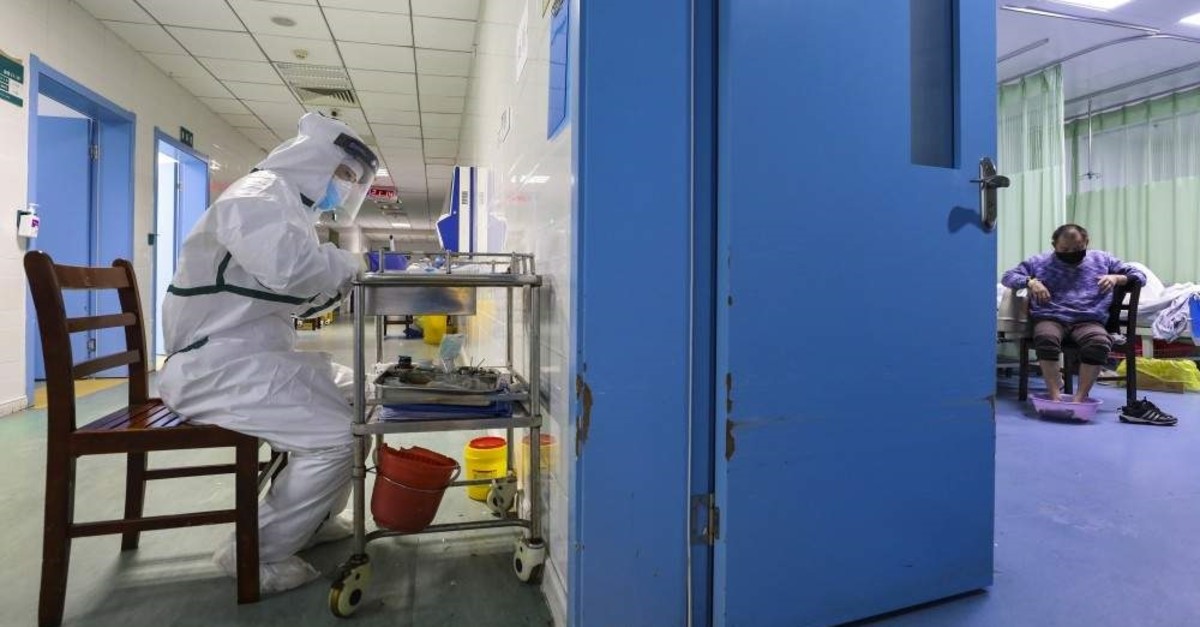 In this Thursday, Feb. 6, 2020, photo, a nurse takes notes in the isolation ward for 2019-nCoV patients at a hospital in Wuhan in central China's Hubei province. (Chinatopix via AP)
