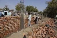 Indian workers construct a wall in front of a slum ahead of U.S. President Donald Trump's visit, in Ahmadabad, India, Monday, Feb. 17, 2020. Trump is scheduled to visit the city during his Feb. 24-25 India trip. (AP Photo)