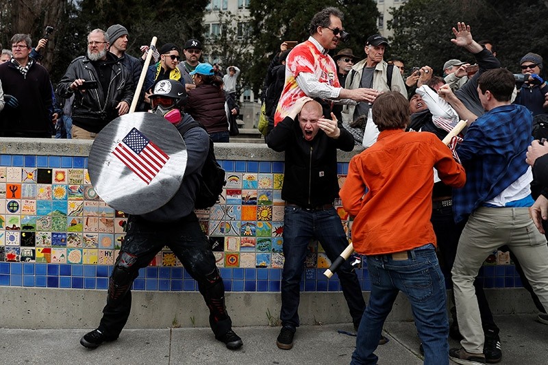 A demonstrator supporting U.S. President Donald Trump (L) holds a shield as a group of men punch a demonstrator during a ,People 4 Trump, rally in Berkeley, California March 4, 2017. (Reuters Photo)