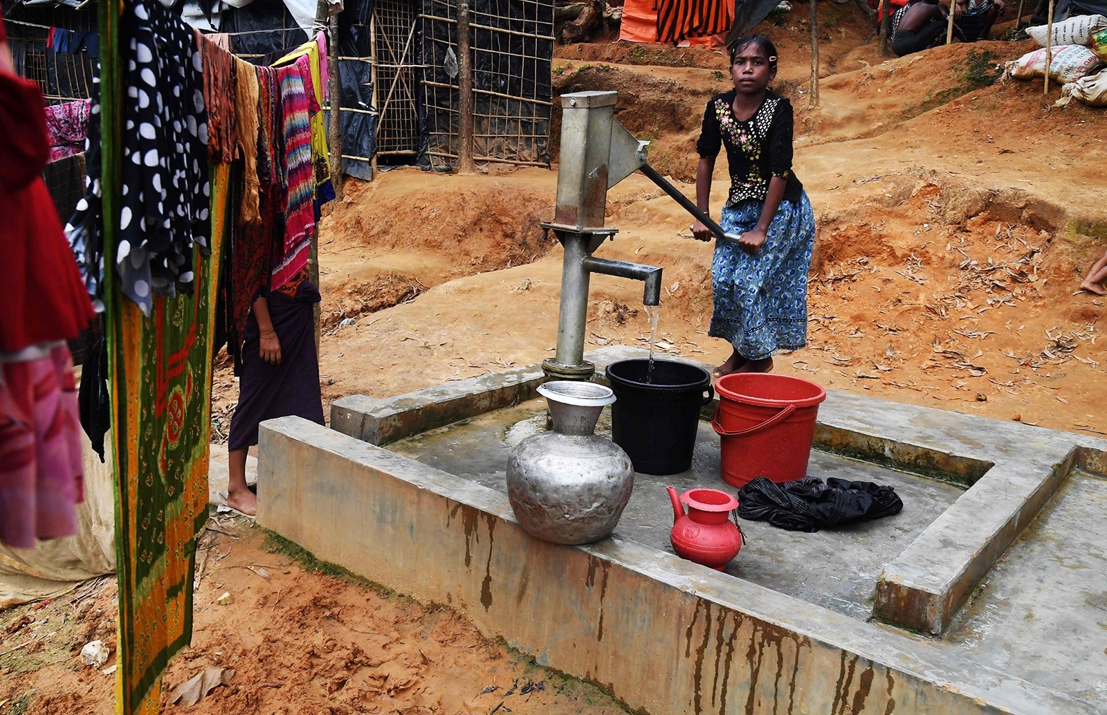 This picture taken November 4, 2017 shows ten-year-old Rohingya refugee Tahera Begum collecting water from a hand-pump at the Balukhali refugee camp in Bangladesh's Ukhia district (AFP Photo)