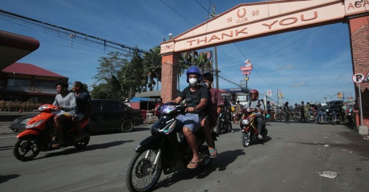 Residents on motorcycles ride back to their homes after the Philippine volcanology bureau lowered the alert level from 4 to 3 and residents were allowed to return home in the town of Lemery, Batangas province, south of Manila on Jan. 26, 2020. (Photo by STR / AFP)