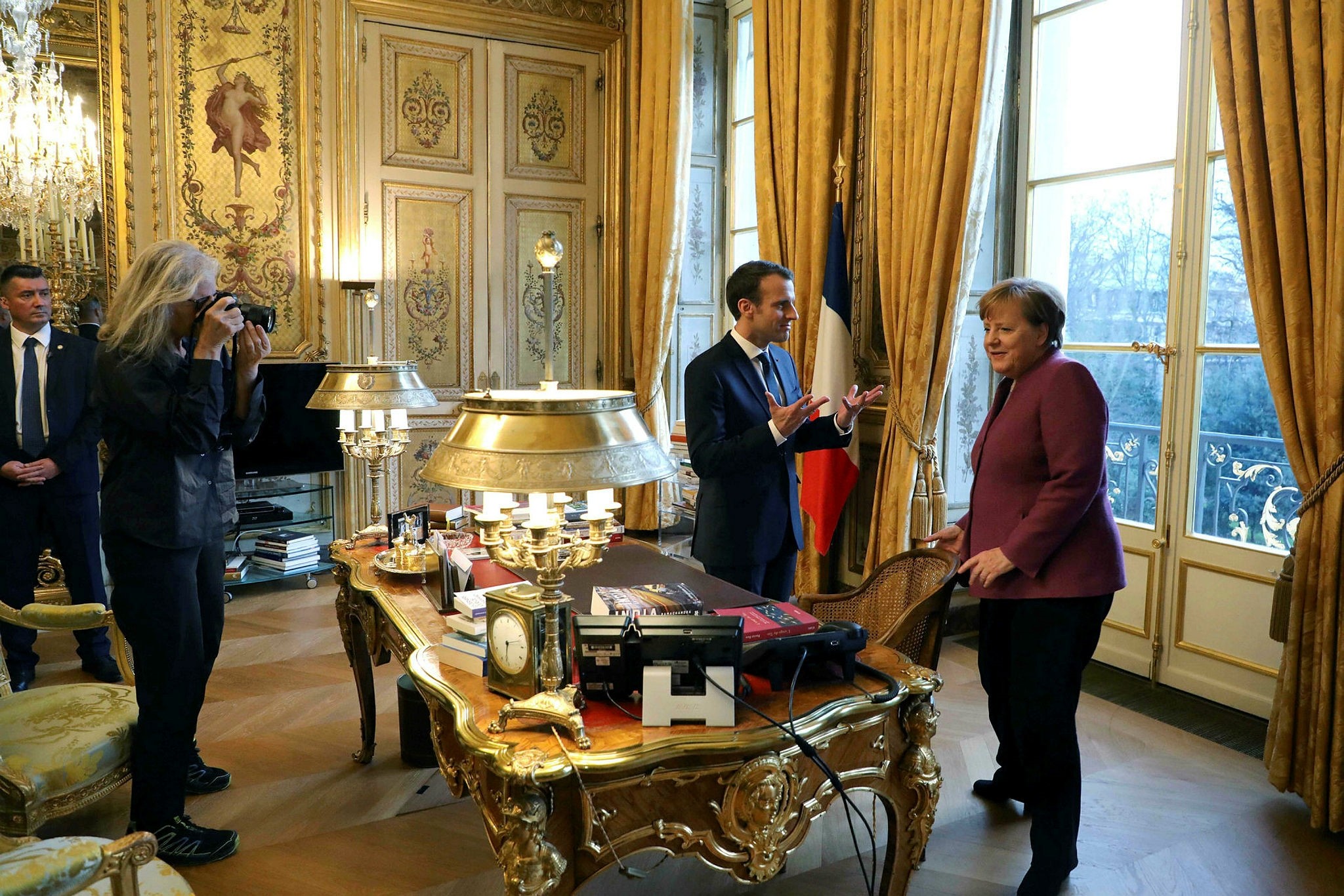 American photographer Annie Leibovitz (L) takes pictures of French President Emmanuel Macron (L) and German Chancellor Angela Merkel meeting at the Eylsee presidential Palace in Paris on March 16, 2018. (AFP Photo)