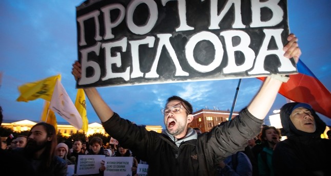 متظاهر يرفع لافتة ضد انتهاكات الشرطة لحقوق المتظاهرين في سان بطرسبورغ AP