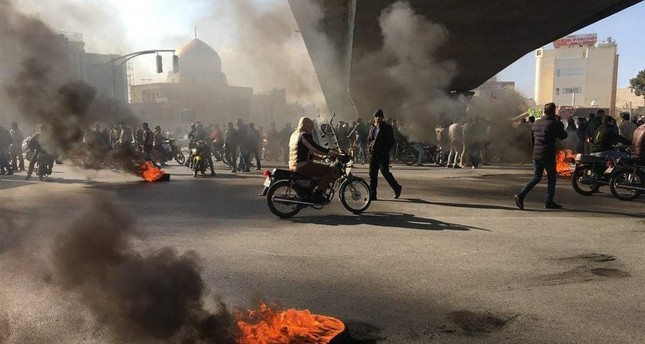 Iranian protesters rally amid burning tires during a demonstration, Isfahan, Nov. 16, 2019. (AFP Photo)