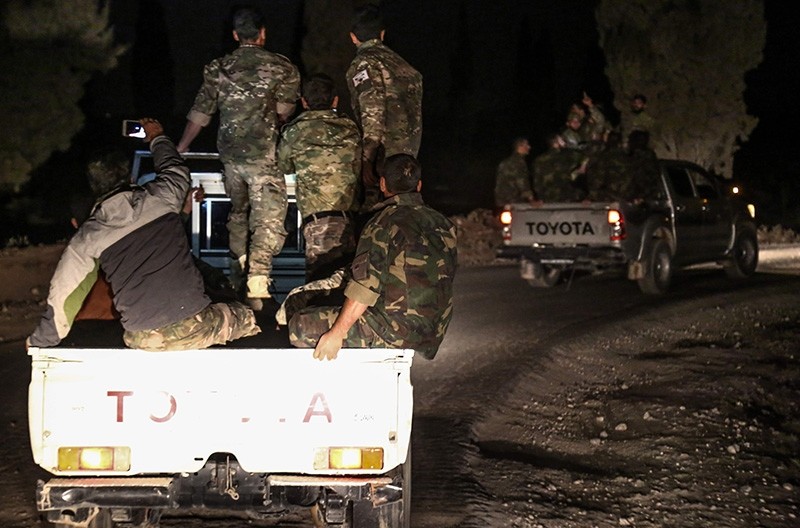 Syrian opposition fighters seen riding on pickup trucks near the village of Hawar Killis along the Turkish border in Aleppo on October 6, 2017 (AFP Photo)