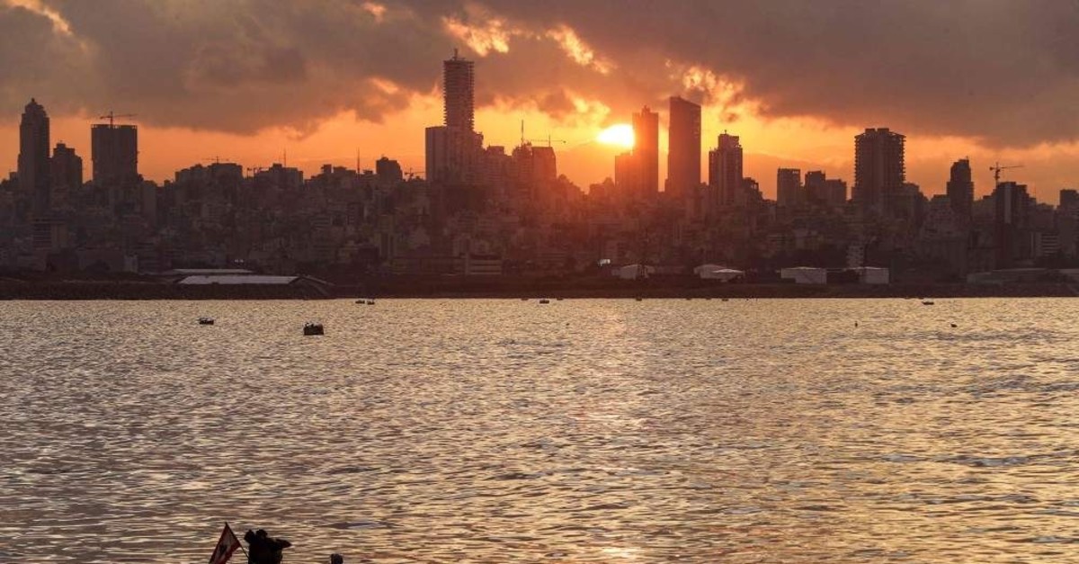Fishermen cast their nets from a boat into the Mediterranean Sea at sunset in the area of Dbayeh, Beirut, Dec. 5, 2019. (AFP Photo)