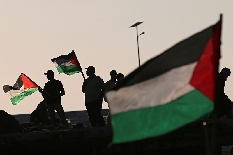 People holding Palestinian flags as they show their solidarity with a Gaza-bound flotilla during a rally in Gaza port in the west of the embattled enclave, 05 October 2016.
